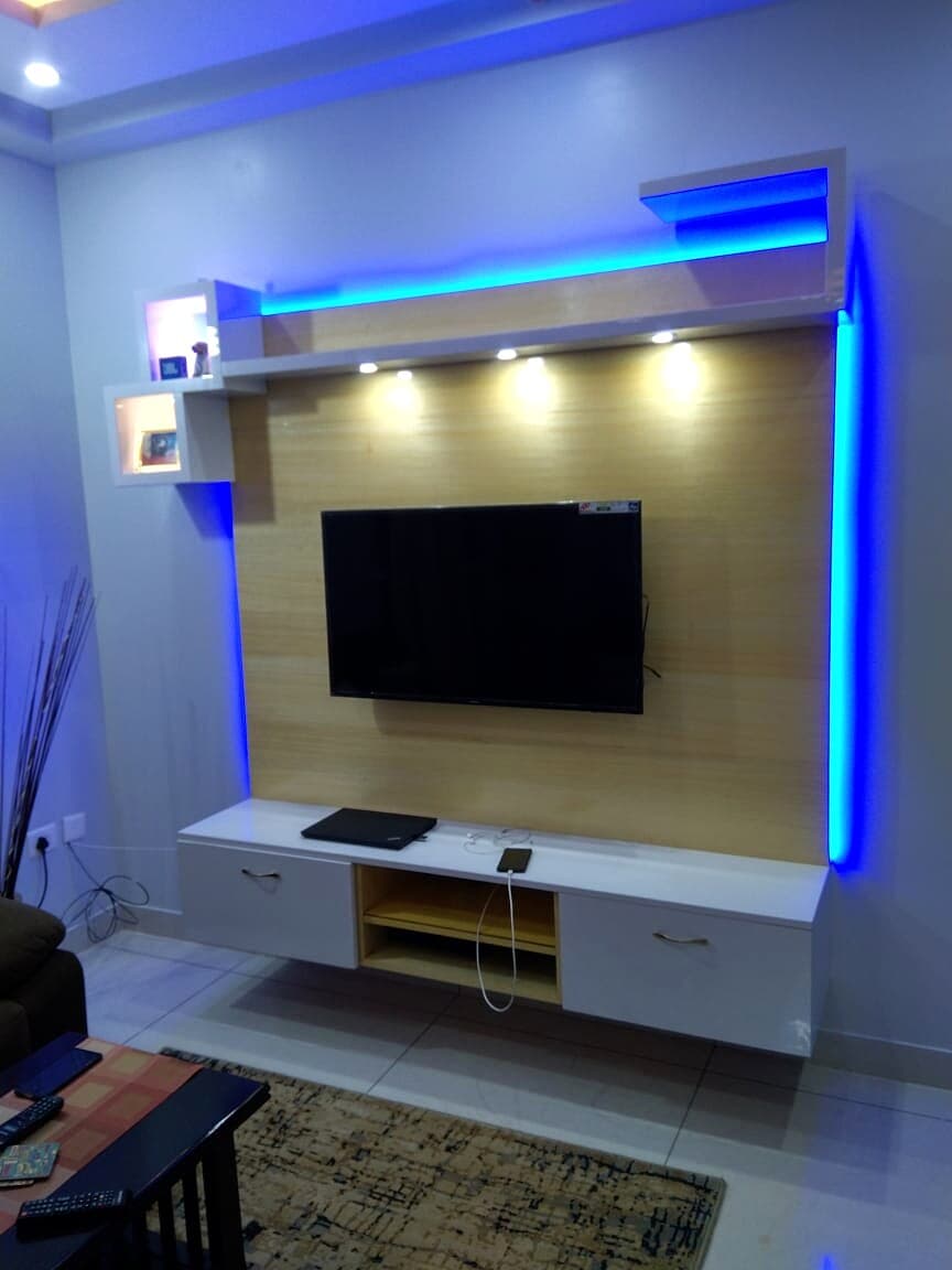Living room TV unit with blue LED lighting and floating storage